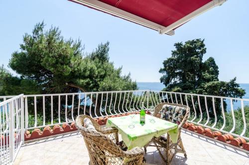 a table and chairs on the balcony of a house at Guest House Daniela in Mlini