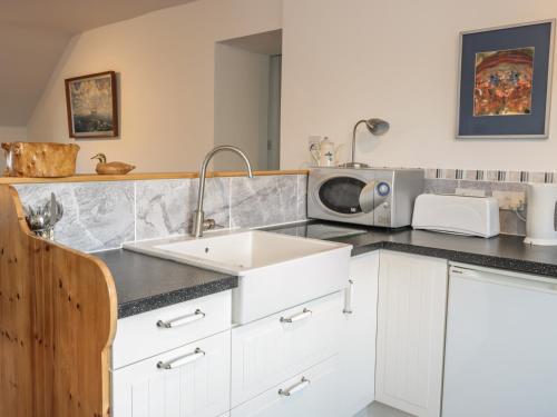 a kitchen with a sink and a microwave at The Rest in Eyemouth