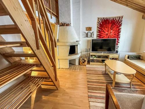 een woonkamer met een trap en een televisie bij Holiday Home Ylläskakkonen b9 by Interhome in Ylläsjärvi