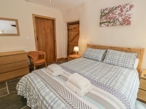 a bedroom with a bed with towels on it at Hendoll Barn in Fairbourne