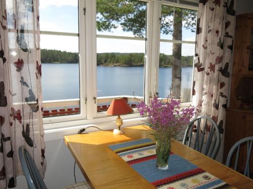 a dining room with a table with a vase of flowers at Holiday Home Ogge by Interhome in Svaland