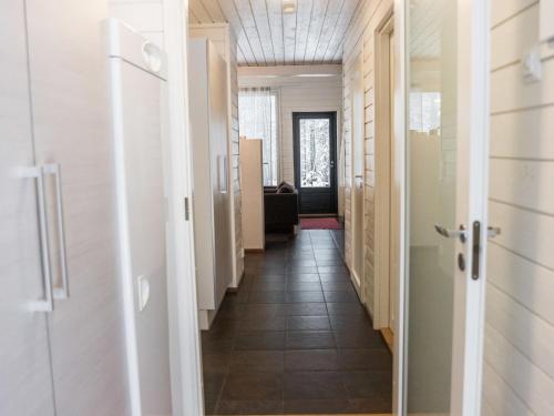 einen Flur mit weißen Türen und Fliesenböden in der Unterkunft Holiday Home Ylläsjuolukka a by Interhome in Ylläsjärvi