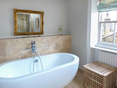 y baño con bañera blanca y espejo. en The Old Forge en Haworth