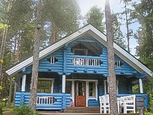 een blauw huis met twee stoelen ervoor bij Holiday Home Päivärinne by Interhome in Mäkisauru