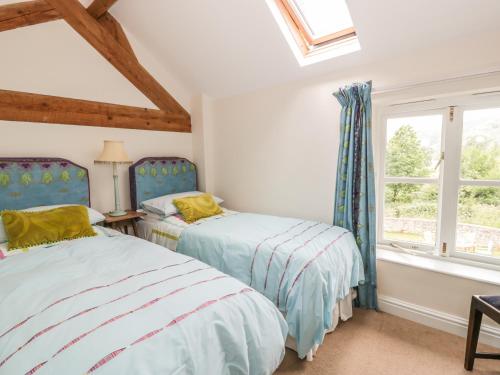two beds in a room with two windows at Bryn Howell Stables in Trevor