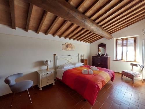 a bedroom with a bed and a desk and a chair at Casa Santa Giulia in Monteriggioni