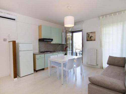 una cucina e un soggiorno con tavolo e sedie bianchi di Apartment Cala Luna-2 by Interhome a Porto dʼAscoli