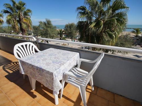 una mesa y sillas en un balcón con vistas a la playa en Apartment Cala Luna-1 by Interhome, en Porto dʼAscoli