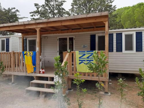 a tiny house with a porch and a deck at Holiday Home Ostro by Interhome in Marina di Bibbona