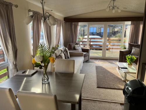 uma sala de estar com uma mesa e um sofá em Hazel Oaks, Beautiful Lodge with Hot Tub - Sleeps 6 - Felmoor Park em Morpeth