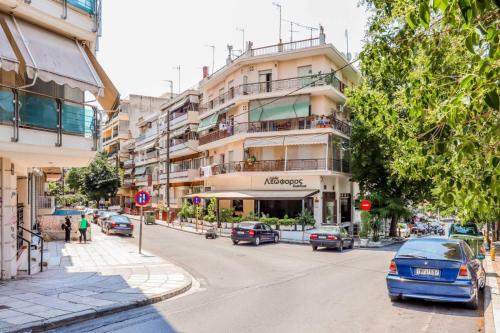 a city street with cars parked in front of a building at HAPPY TRAVELLER - Luxury, Free Parking in Thessaloniki