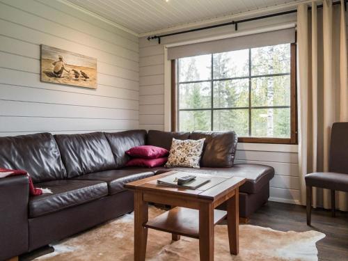 a living room with a leather couch and a table at Holiday Home Tahkovuorentie 34 b by Interhome in Tahkovuori