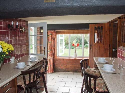 een keuken met een tafel en stoelen en een raam bij Severn Bank Lodge in Shrawley