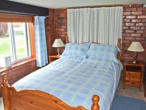 ShrawleyにあるSevern Bank Lodgeのベッドルーム1室(ベッド1台、ランプ2つ、窓付)