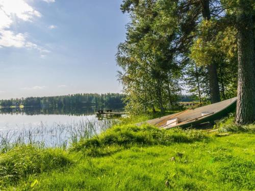 a boat sitting on the grass next to a lake at Holiday Home Saniainen 5 by Interhome in Säviä