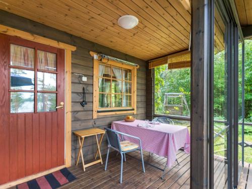 - une terrasse couverte avec une table, des chaises et une porte dans l'établissement Holiday Home Metsä-iivari by Interhome, à Piispala