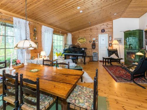 une salle à manger avec une table en bois et un piano dans l'établissement Holiday Home Metsä-iivari by Interhome, à Piispala