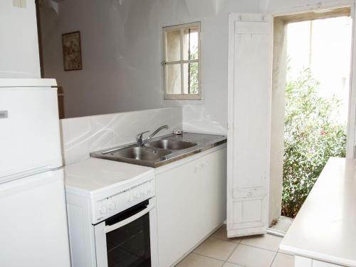 a white kitchen with a sink and a window at Holiday Home La Cadièrienne by Interhome in La Cadière-dʼAzur