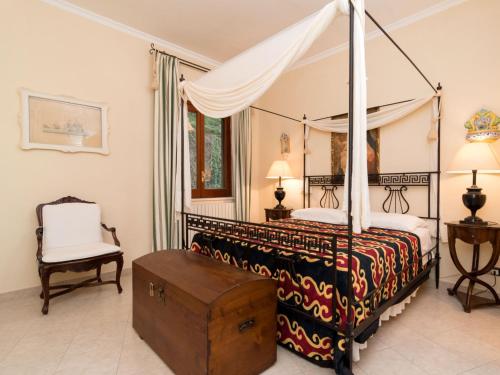波西塔諾的住宿－Apartment Positano Elegant Terrace by Interhome，一间卧室配有一张天蓬床和一把椅子