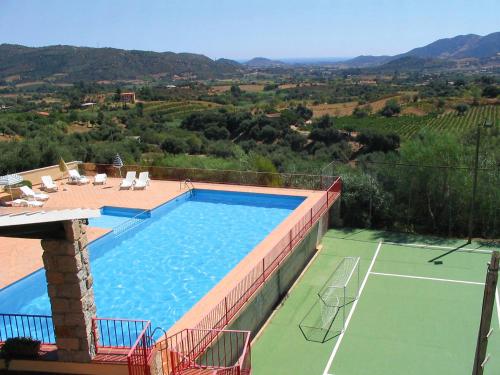 a swimming pool with a tennis court and a tennis court at Apartment Is Murtas-4 by Interhome in Cardedu