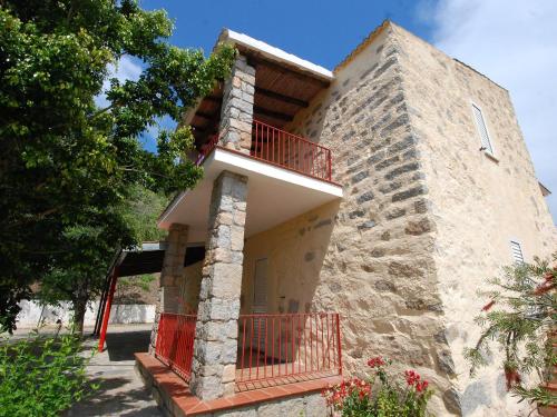 un edificio con una puerta roja y un balcón en Apartment Is Murtas-4 by Interhome, en Cardedu