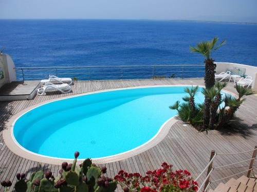 una piscina con vista sull'oceano sullo sfondo di Apartment La Rosa-4 by Interhome a Plemmirio
