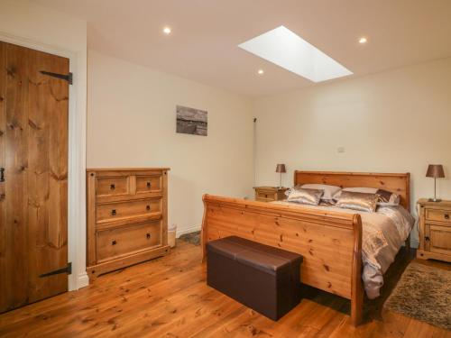 a bedroom with a bed and wooden furniture and a skylight at The Smithy in Bodmin
