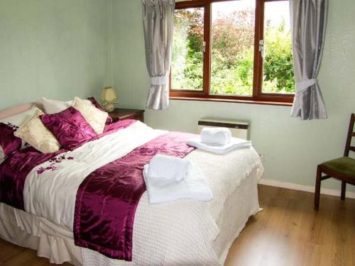 Un dormitorio con una cama grande y una ventana en Bryn yr Haf, en Llanfair Clydogau