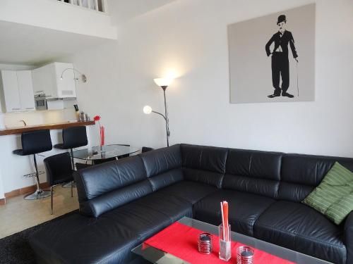 un salon avec un canapé en cuir noir et une table dans l'établissement Apartment Les Cascadelles-5 by Interhome, à La Foux