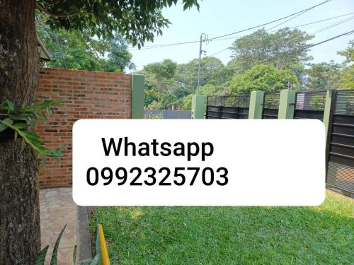 a sign that sayswhatsap in front of a fence at Casa Naranja in San Lorenzo