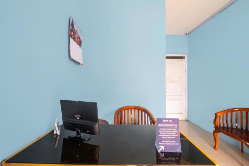 a room with a desk with a computer and chairs at RedDoorz Syariah At Jl Pangeran Hidayatullah Cianjur in Tjiandjur