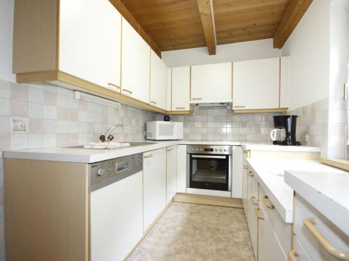 eine Küche mit weißen Schränken und einem Waschbecken in der Unterkunft Apartment Falkner-8 by Interhome in Oberlängenfeld