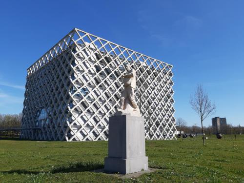 eine Statue auf einem Feld vor einem Gebäude in der Unterkunft Short Stay Wageningen in Wageningen