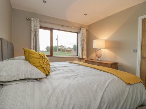 a bedroom with a large bed with a window at Little Acres in Selby