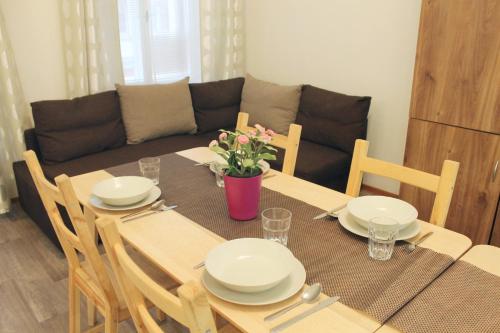 a dining room table with white plates and flowers on it at Modern Apartment Ve Smečkách 28 in Prague