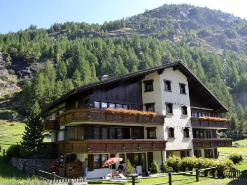 a large building with a mountain in the background at Apartment Sunshine by Interhome in Saas-Grund