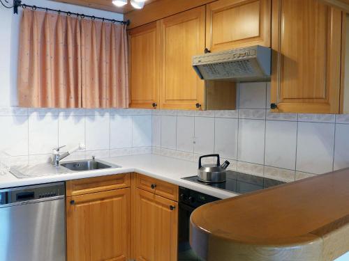eine Küche mit Holzschränken und einem Waschbecken in der Unterkunft Apartment Utoring Plaz 030 by Interhome in Bivio