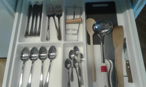 a plastic container filled with spoons and forks and knives at Apartamentai su terasa Elija in Šventoji