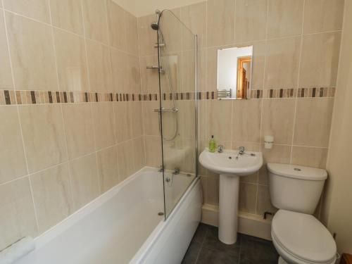 a bathroom with a toilet and a sink and a shower at Calf House in Sutton