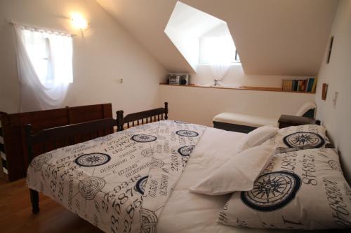 a bedroom with a bed with a white and black comforter at Apartments More in Kaštela