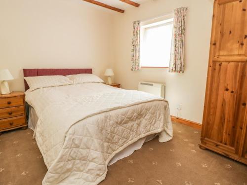 a bedroom with a large bed and a window at Chestnut Cottage in Great Edston