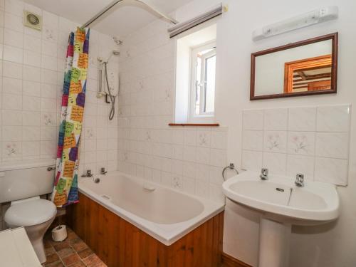 a bathroom with a tub and a sink and a toilet at Chestnut Cottage in Great Edston