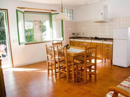 a kitchen with a table and chairs and a refrigerator at Apartment Masia Torrents 5 by Interhome in Segur de Calafell