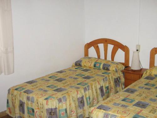 セグル・デ・カラフェルにあるApartment Masia Torrents by Interhomeのベッドルーム1室(ベッド2台、テーブル、ベッドカバー付)