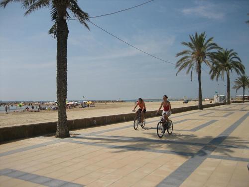 セグル・デ・カラフェルにあるApartment Masia Torrents by Interhomeのビーチ近くの歩道を自転車に乗って2人
