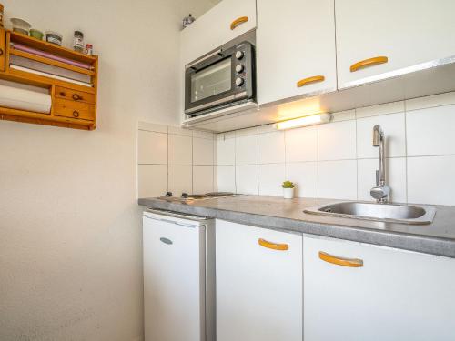 une cuisine avec un évier et un micro-ondes dans l'établissement Apartment Port Athéna by Interhome, à La Grande Motte