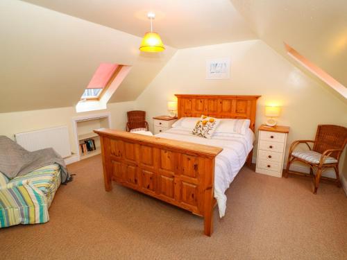 a bedroom with a large wooden bed in a attic at Tynk in Saint Merryn