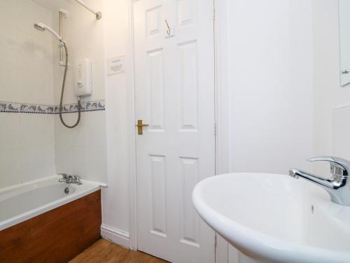 a bathroom with a sink and a white door at Tynk in Saint Merryn