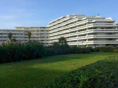 een groot wit gebouw met een gazon ervoor bij Apartment Le Beaupré-21 by Interhome in Canet-en-Roussillon