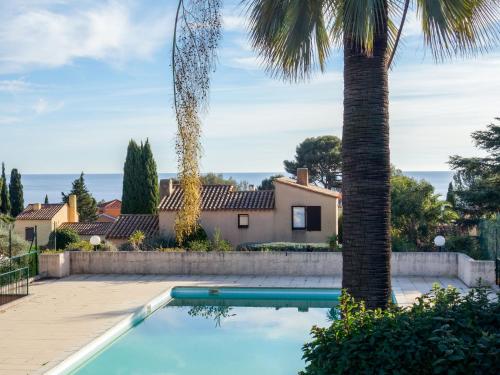 une piscine devant une maison avec un palmier dans l'établissement Apartment Le Bali-2 by Interhome, à La Ciotat